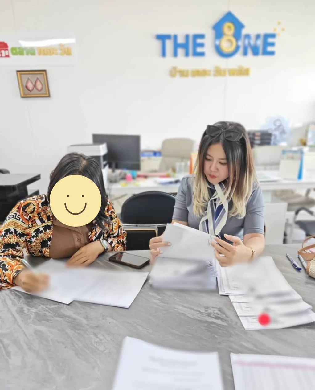 ลูกแก้วด้านขวาร่วมดูเอกสารกับผู้แทนโครงการด้านซ้าย โดยปิดใบหน้าผู้แทนโครงการ