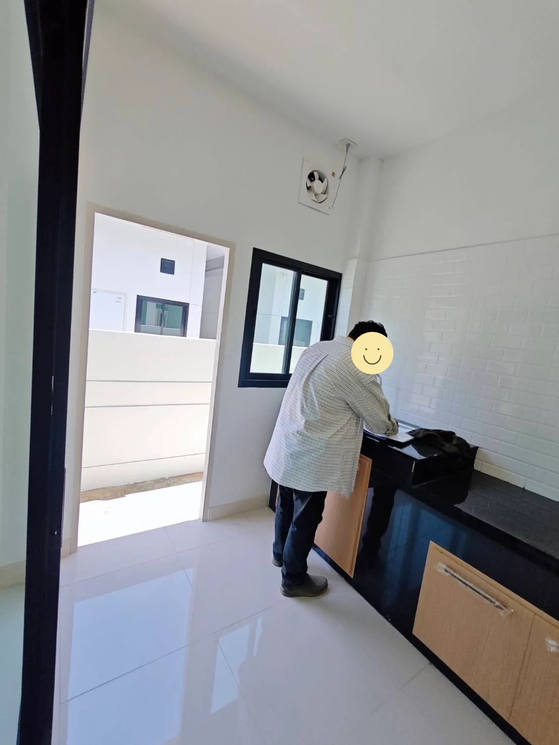 เจ้าหน้าที่สำรวจพื้นที่ครัว โดยปกป้องใบหน้าที่มองเห็น
